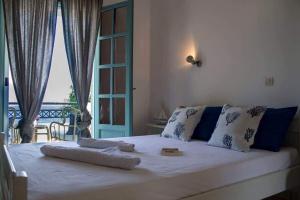 una camera da letto con un grande letto bianco con una finestra di VILLA AKTI a Mochlos