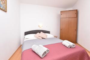 een slaapkamer met een groot bed en handdoeken bij Apartment Nensi in Primošten