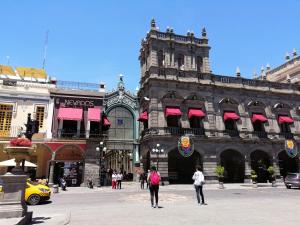 a group of people walking in front of a building at Hotel La Alhondiga in Puebla