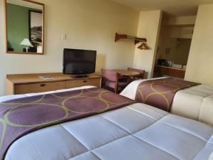 a hotel room with two beds and a television at Mission Inn San Luis Obispo in San Luis Obispo