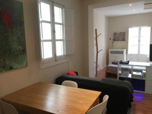 sala de estar con mesa y sofá en Vidrio Apartment, en Sevilla