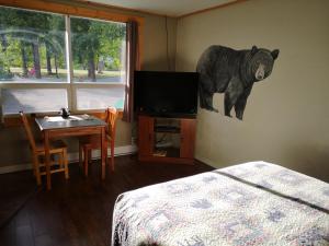 a bedroom with a bear painting on the wall at Overlook Inn & Cabins in Clearwater