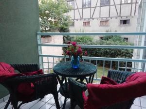 a table with a vase of flowers on a balcony at LE KATZALA in Mulhouse