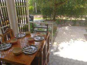 uma mesa de madeira com pratos e pratos em Palm Garden House em Ko Lanta