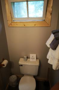y baño con aseo, ventana y toallas. en Overlook Inn & Cabins, en Clearwater