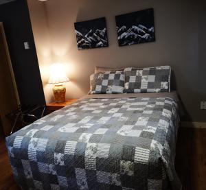 a bedroom with a bed with a checkered blanket at Overlook Inn & Cabins in Clearwater
