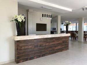 a lobby with a reception counter with flowers on it at GRAN PARADA HOTEL in Castanhal