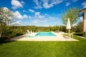 a swimming pool in a yard with an umbrella at Casa do Mundo in Calhariz +23 photos