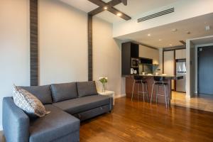 a living room with a couch and a kitchen at Anggun Residences Luxe in Kuala Lumpur