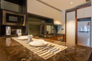 a kitchen with a table with plates and utensils on it at Anggun Residences Luxe in Kuala Lumpur +122 photos