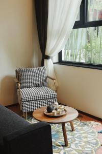 a living room with a chair and a coffee table at Peking Yard Siheyuan Boutique Hotel &Garden&Terrace&Lama Temple&hutong&Houhai&Tiananmen&Bistro in Beijing