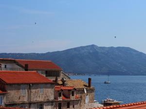 a view of a body of water with houses and mountains at Guest House Dijana in Korčula