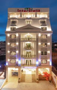 a large white building with a sign on it at Interstella Hotel in Da Lat
