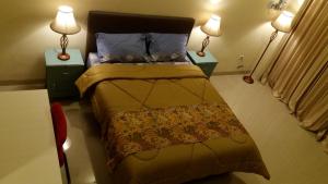 una camera con un letto con due comodini e due lampade di Royal Adem Mejing a Ngabean