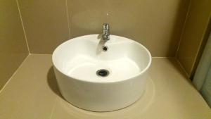 un lavandino bianco con rubinetto in bagno di Royal Adem Mejing a Ngabean