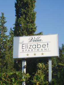 a sign for a restaurant in front of a tree at Apartments Villa Elizabet in Malinska