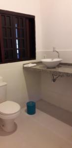 a bathroom with a white toilet and a sink at Apartamentos de Férias por Temporada Martim De Sá in Caraguatatuba +25 photos