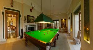 a pool table in a living room with a green at Ramgarh Lodge, Jaipur – IHCL SeleQtions in Jaipur
