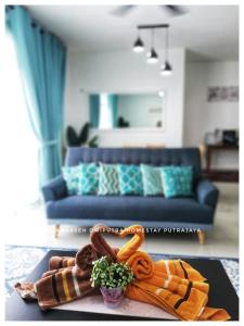 SulamKaseh Dwiputra Homestay Putrajaya With 4 Units AC, 3 Baths, WiFi & Pool View في بوتراجايا: غرفة معيشة مع أريكة زرقاء وطاولة