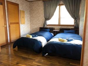 a bedroom with two beds and a window at Apartment at Toemu Nozawa in Nozawa Onsen