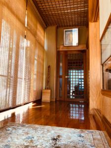 Habitación con suelo de madera y puerta con ventanas. en Apartment at Toemu Nozawa, en Nozawa Onsen
