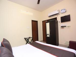 ein Schlafzimmer mit einem Bett und einem Fernseher an der Wand in der Unterkunft Hotel Aparajita in Varanasi + 51 Fotos