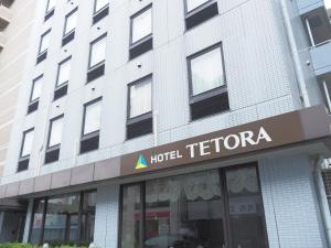 un hotel t acreedor firma en la parte delantera de un edificio en Hotel Tetora Makuhari Inagekaigan (Formerly Business Hotel Marine) en Chiba
