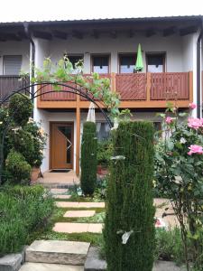 a house with a garden with bushes and a walkway at Ferienappartement Souterrain in Volkertshausen