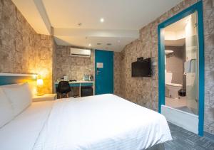 Schlafzimmer mit einem großen weißen Bett und einem Schreibtisch in der Unterkunft 9ine Hotel in Taipeh
