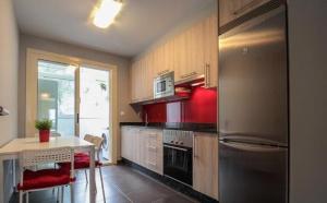a kitchen with a stainless steel refrigerator and a table at Apartamento Covelo in Poio