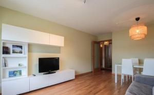 a living room with a flat screen tv on a white cabinet at Apartamento Covelo in Poio