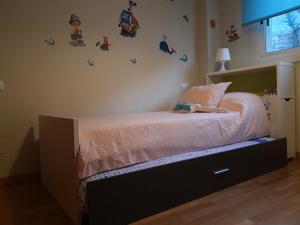 a bedroom with a bed with pink sheets and birds on the wall at Apartamento Covelo in Poio +22 photos