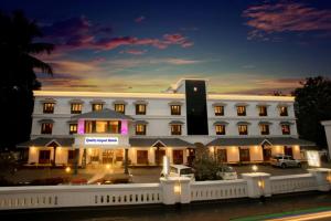 a large white building with lights in front of it at Quality Airport Hotels in Nedumbassery