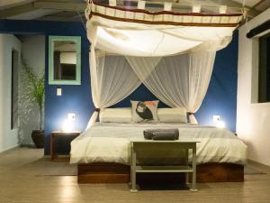 a bedroom with a bed with a canopy at Casa Narinho in Praia do Tofo