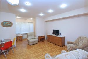 a living room with a couch and a tv and a table at Top Apartments - Yerevan Centre in Yerevan
