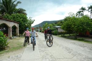 a group of people riding bikes down a road at Ciudad de Las Rocas in La Fortuna Gallo Giro