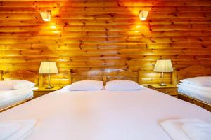 a bedroom with wooden walls and a bed with two lamps at Casa Ivett in Braşov