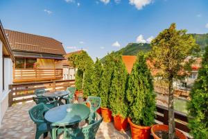 Un patio con mesas y sillas y árboles en macetas. en Casa Ivett, en Brasov