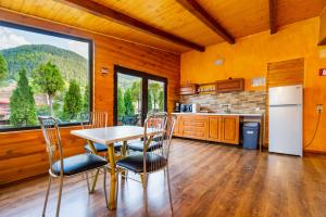 cocina con mesa y sillas y ventana grande en Casa Ivett, en Brasov