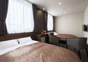 a hotel room with a bed and a desk and a table at Credo Hotel Hakodate in Hakodate +26 photos