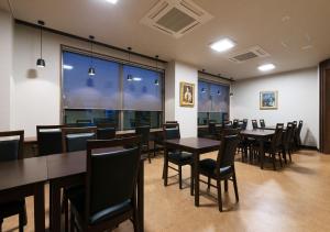 a restaurant with tables and chairs and a large window at Credo Hotel Hakodate in Hakodate