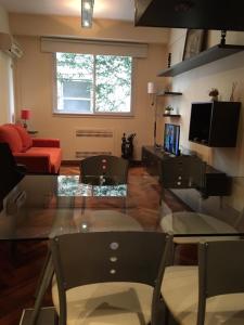 uma sala de estar com uma mesa de vidro e um sofá vermelho em Confortable 2 ambientes en Recoleta Excelente Ubicacion em Buenos Aires