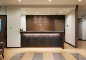 un vestíbulo con una gran puerta de madera en un edificio en Credo Hotel Hakodate, en Hakodate