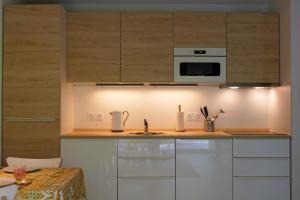 a kitchen with white cabinets and a stove top oven at BaskoParadis I Apt I Central I Calme I Lumineux I Lit 160 I Terrasse I Jardin in Cambo-les-Bains