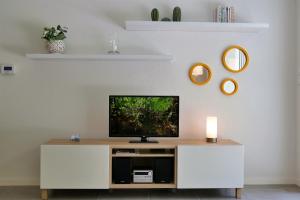 a living room with a tv on a white cabinet at BaskoParadis I Apt I Central I Calme I Lumineux I Lit 160 I Terrasse I Jardin in Cambo-les-Bains