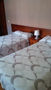 ein Schlafzimmer mit 2 Betten und einer Lampe auf einem Tisch in der Unterkunft Hotel El Sueve in Colunga