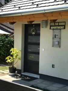 ein Haus mit einer schwarzen Tür und einem Schild darauf in der Unterkunft ‘Feel So Good’ apartment in Göd