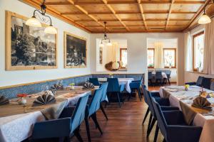 a dining room with long tables and blue chairs at Apart Sunshine in Ladis