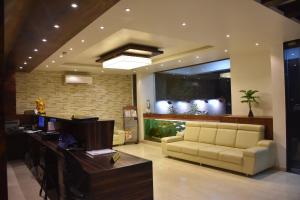 a lobby with a couch and a fish tank at Heritage Inn in Mysore