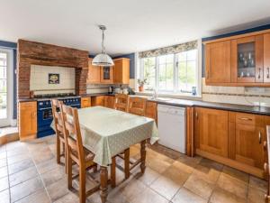 a kitchen with wooden cabinets and a table with chairs at Pinley Hill House in Warwick